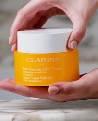 a person holding a jar of clarins moisturiser